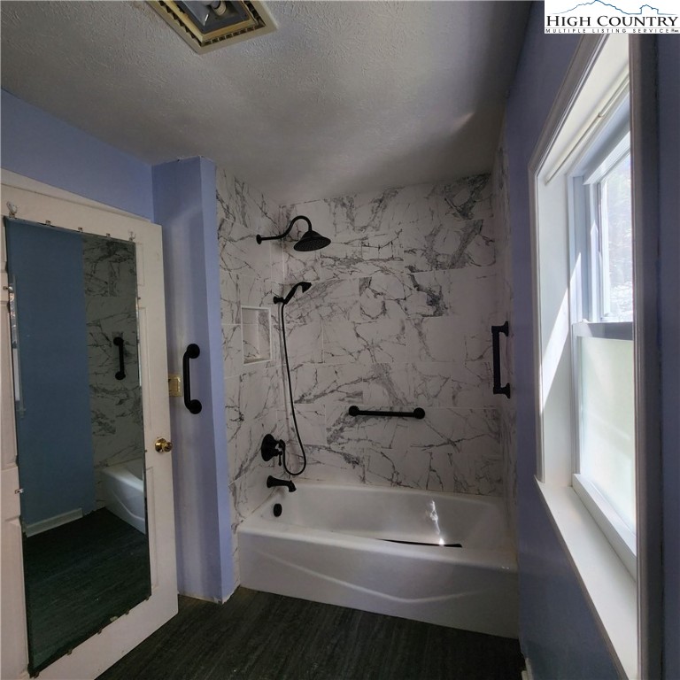 336 Willowdale Church Road Vilas, NC 28692 - Photo 15 of 35 a bathroom with a bathtub a window and a shower