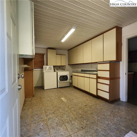 a kitchen with a refrigerator a stove top oven a sink and cabinets