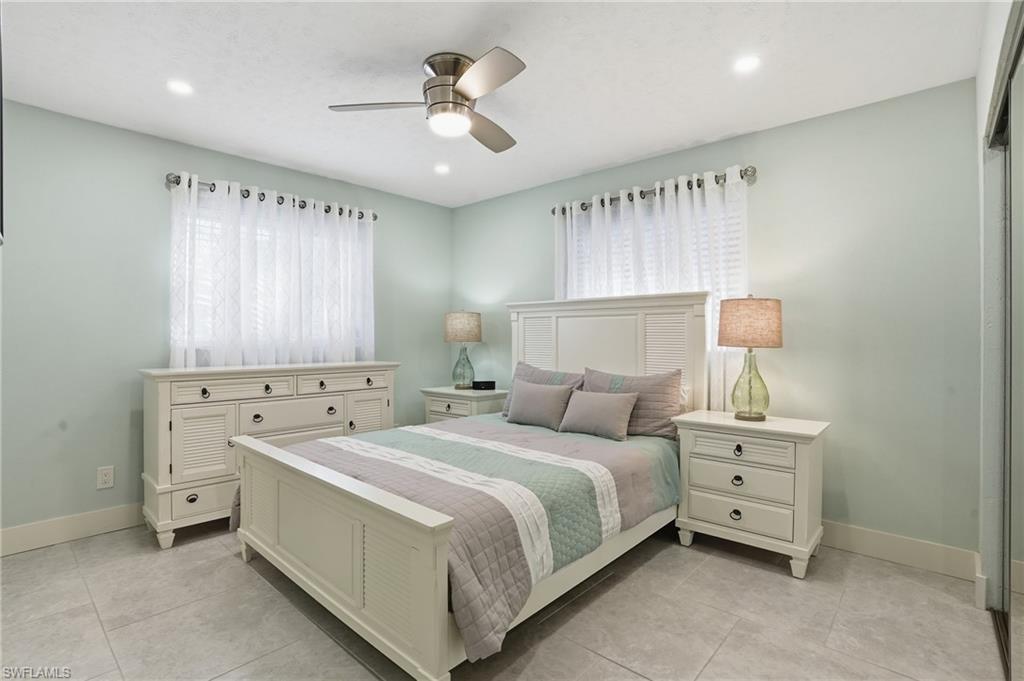 560 109th Avenue North Naples, FL 34108 - Photo 15 of 37 a bedroom with a bed and a chandelier