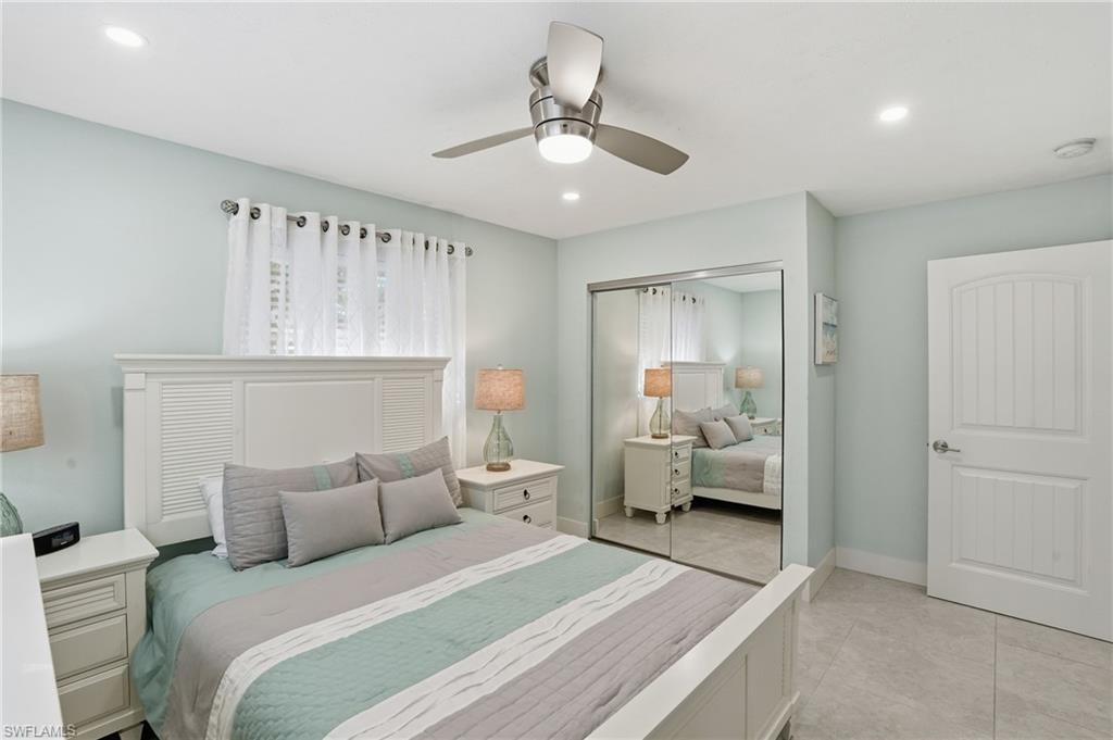 560 109th Avenue North Naples, FL 34108 - Photo 17 of 37 a bedroom with a bed and a chandelier