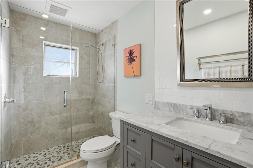 560 109th Avenue North Naples, FL 34108 - Photo 21 of 37 a bathroom with a granite countertop sink a toilet and a shower