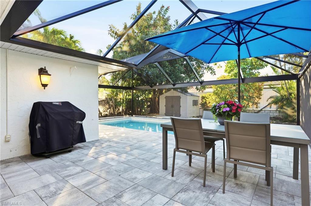 560 109th Avenue North Naples, FL 34108 - Photo 27 of 37 a view of a patio with a table and chairs under an umbrella