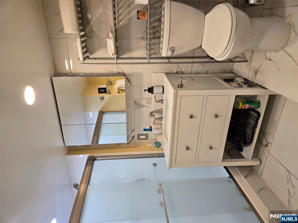 282 Harding Avenue, Unit 1 Teaneck, NJ 07666 - Photo 13 of 21 a bathroom with a sink toilet vanity and tub