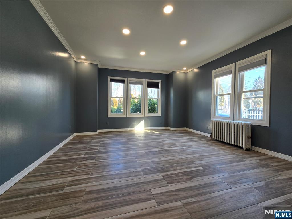 282 Harding Avenue, Unit 1 Teaneck, NJ 07666 - Photo 4 of 21 a view of an empty room with wooden floor and a window