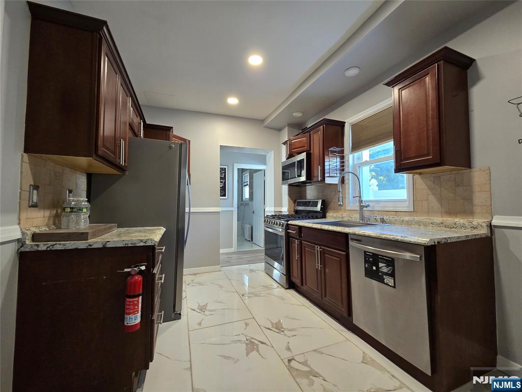 282 Harding Avenue, Unit 1 Teaneck, NJ 07666 - Photo 6 of 21 a kitchen with stainless steel appliances granite countertop a stove a sink dishwasher and a refrigerator