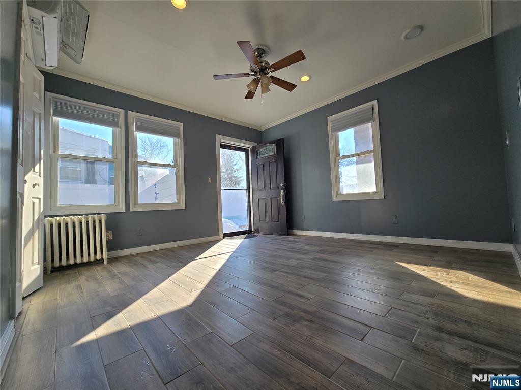 282 Harding Avenue, Unit 1 Teaneck, NJ 07666 - Photo 8 of 21 a view of an empty room with wooden floor and a window