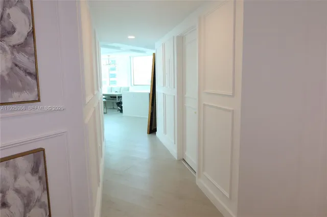 a view of a hallway with furniture and a window