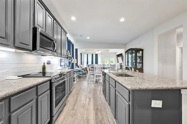 a kitchen with stainless steel appliances granite countertop a sink stove and refrigerator