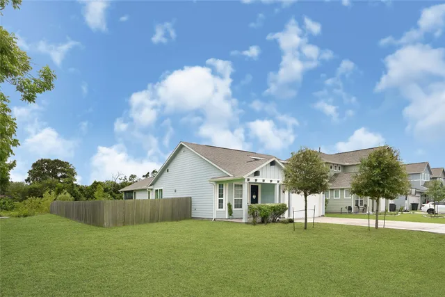 a view of a house with a big yard and large trees