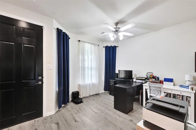 a view of a workspace with furniture and a window