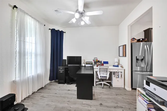 a view of a kitchen with refrigerator and workspace