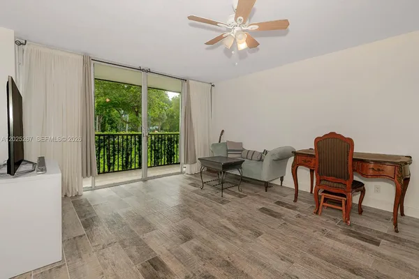 a view of a livingroom with lounge chair and a large window