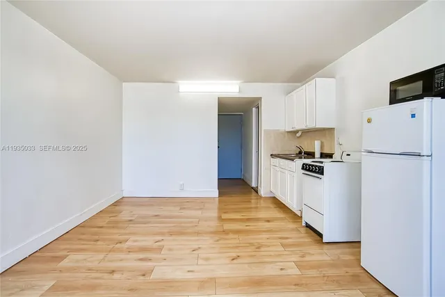 a kitchen with a refrigerator and a stove top oven
