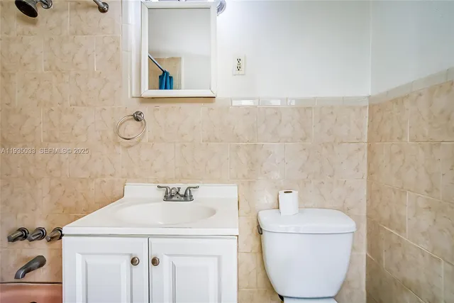 a bathroom with a sink a toilet and mirror