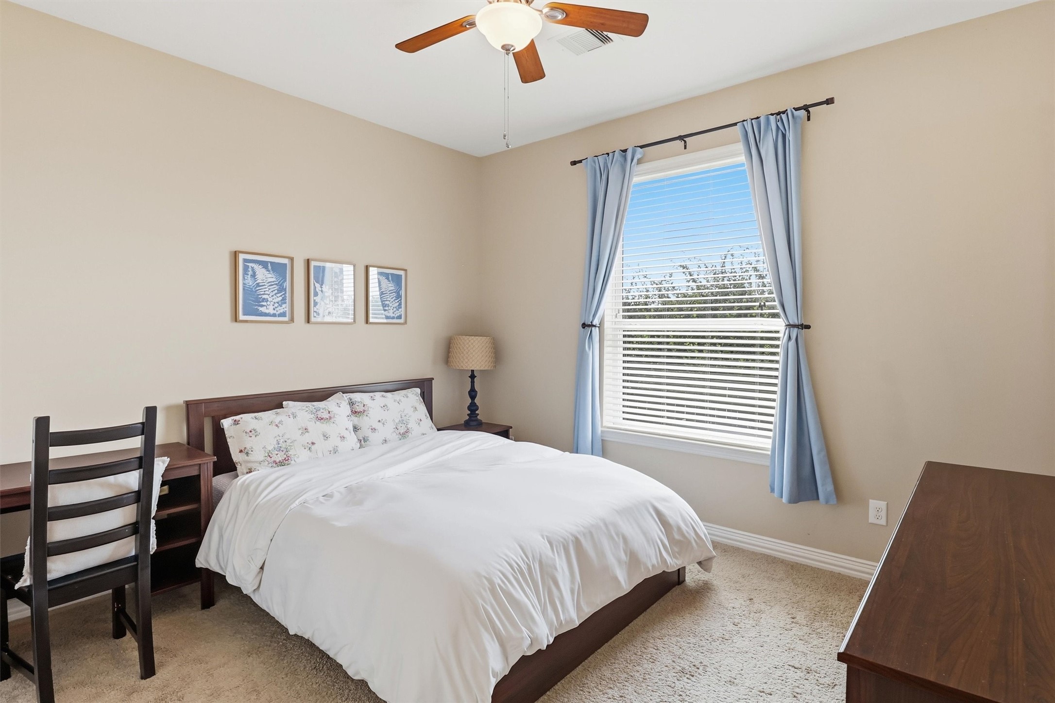 3219 Cotton Ranch Drive Katy, TX 77494 - Photo 22 of 45 This spacious first-floor secondary bedroom offers plush carpeting, abundant natural light, a ceiling fan, and a generous closet, creating a comfortable retreat for family or overnight guests. A nearby full bathroom adds everyday convenience.