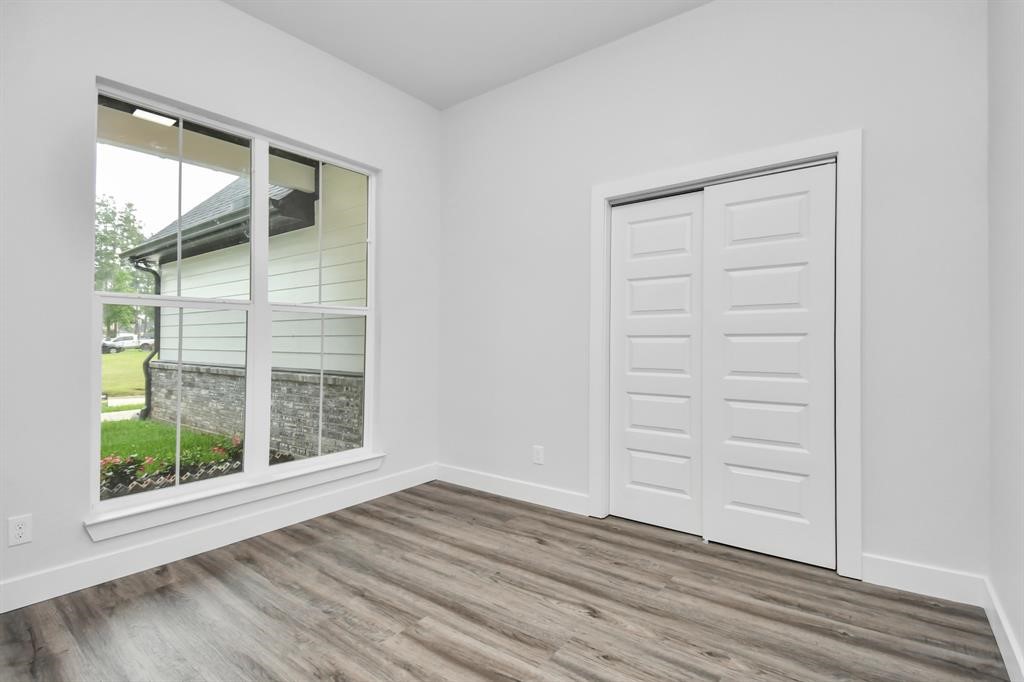 12163 La Salle River Road Conroe, TX 77304 - Photo 6 of 27 an empty room with wooden floor and windows