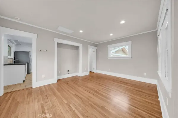 a view of empty room with wooden floor