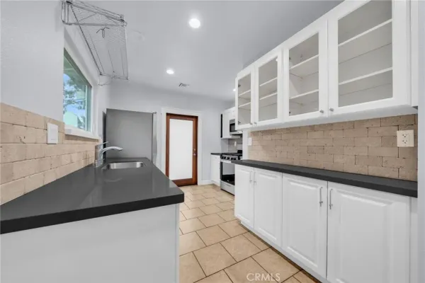 a kitchen with granite countertop a sink and a stove