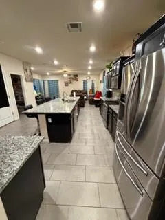 a kitchen with kitchen island granite countertop a refrigerator and a stove