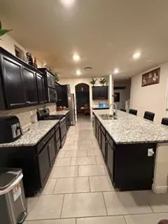 a kitchen with stainless steel appliances granite countertop a sink and a stove top oven