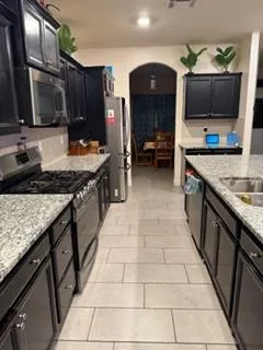 a kitchen with stainless steel appliances granite countertop a sink stove and cabinets