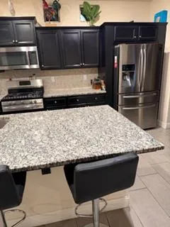 a kitchen with stainless steel appliances granite countertop a sink stove and cabinets