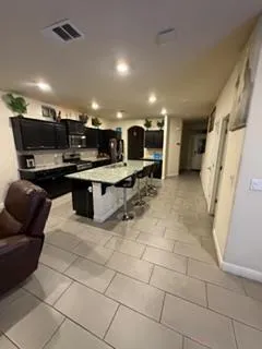 a large kitchen with kitchen island a sink counter top and stainless steel appliances