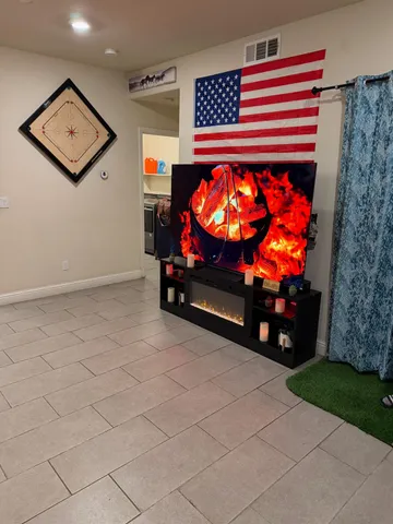 a living room with furniture a flat screen tv and a fireplace