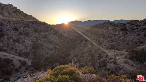 a view of a house with a mountain and mountains in the background