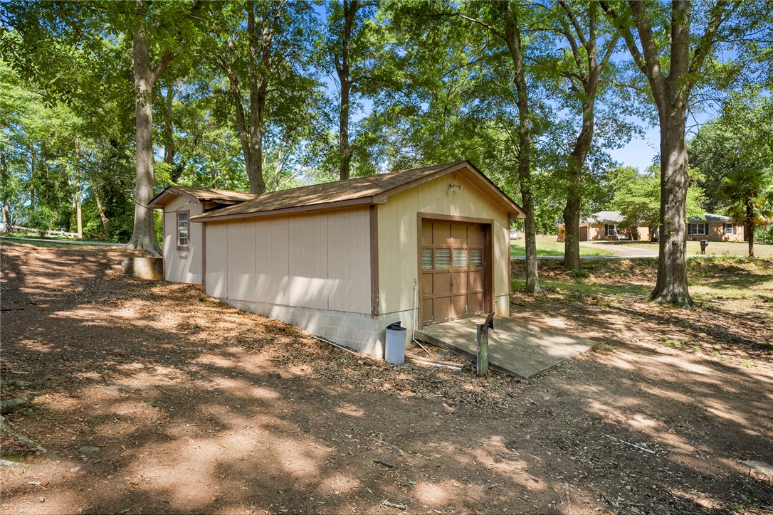 2101 Old Spring Drive Anderson, SC 29625 - Photo 25 of 36 A detached garage provides ample storage or workshop space amidst a verdant, wooded backdrop.