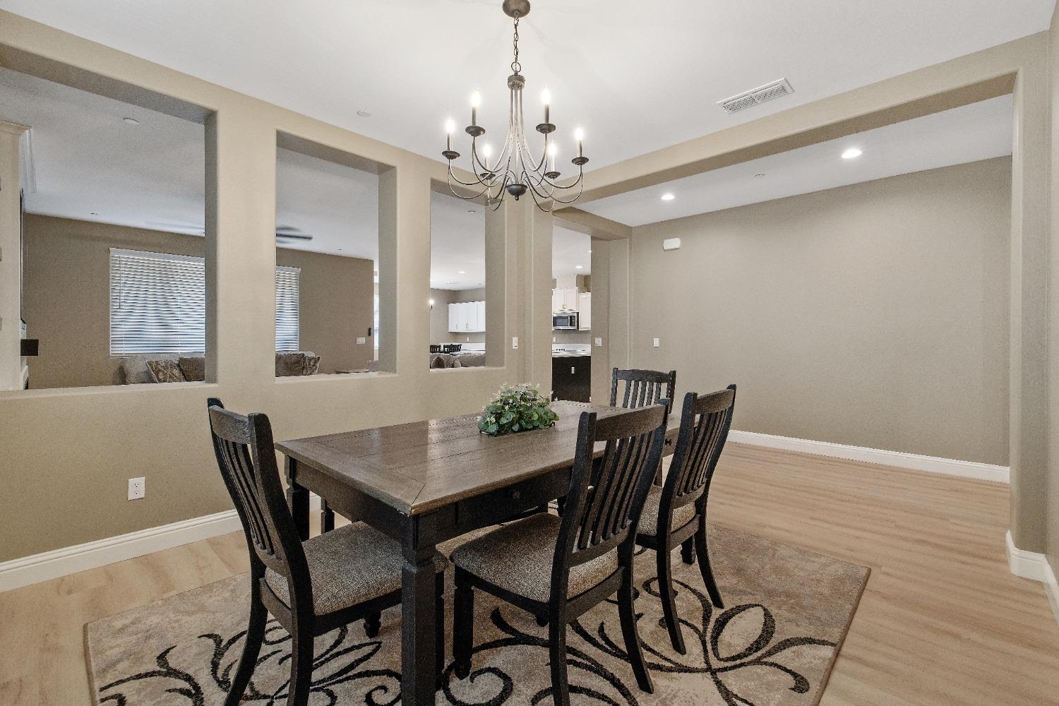 1210 Ridge Creek Estates Way Dinuba, CA 93618 - Photo 15 of 50 a view of a dining room with furniture and chandelier