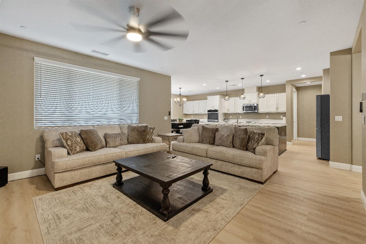1210 Ridge Creek Estates Way Dinuba, CA 93618 - Photo 19 of 50 a living room with furniture white walls and a chandelier