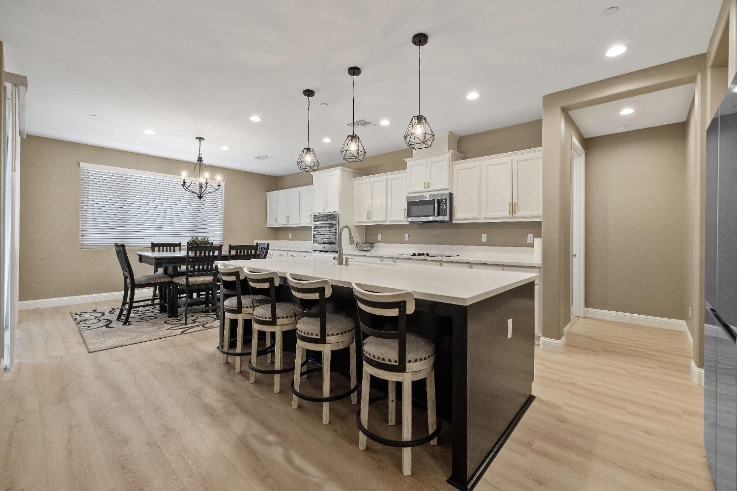 1210 Ridge Creek Estates Way Dinuba, CA 93618 - Photo 22 of 50 a kitchen with lots of wooden furniture a sink stainless steel appliances and cabinets