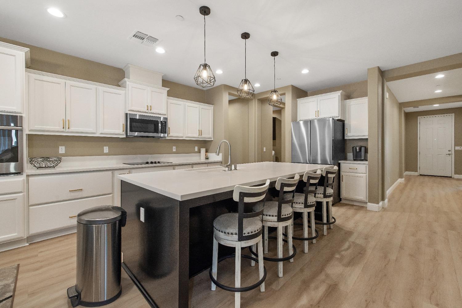 1210 Ridge Creek Estates Way Dinuba, CA 93618 - Photo 23 of 50 a kitchen with kitchen island granite countertop a sink and a refrigerator