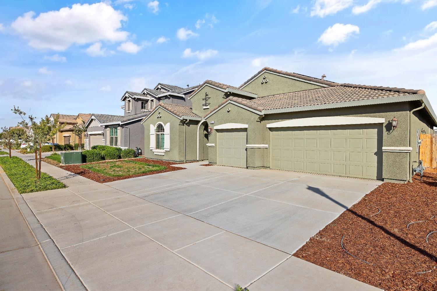1210 Ridge Creek Estates Way Dinuba, CA 93618 - Photo 3 of 50 a view of a white house with a small yard and large tree