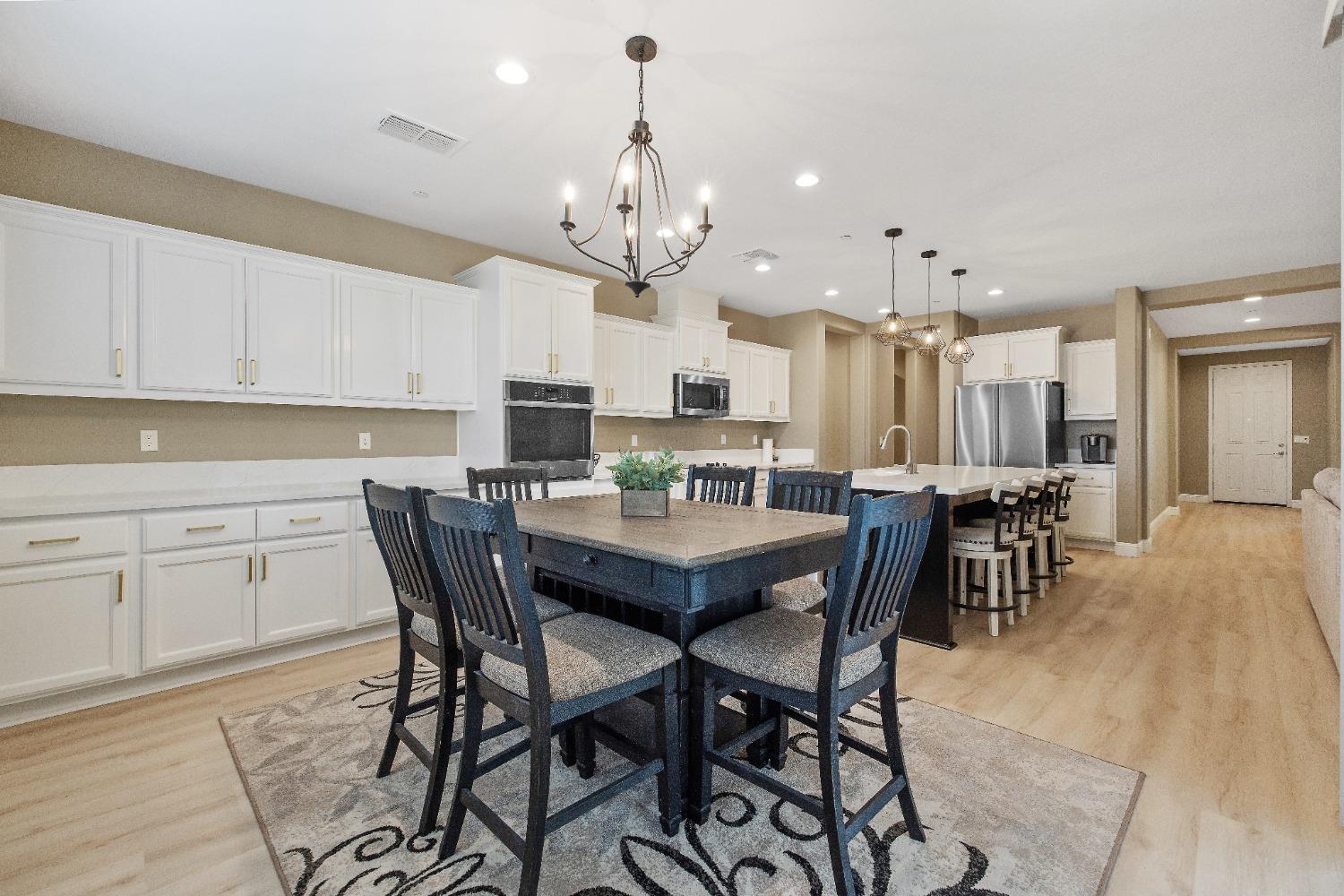 1210 Ridge Creek Estates Way Dinuba, CA 93618 - Photo 31 of 50 a view of a dining room with furniture and chandelier