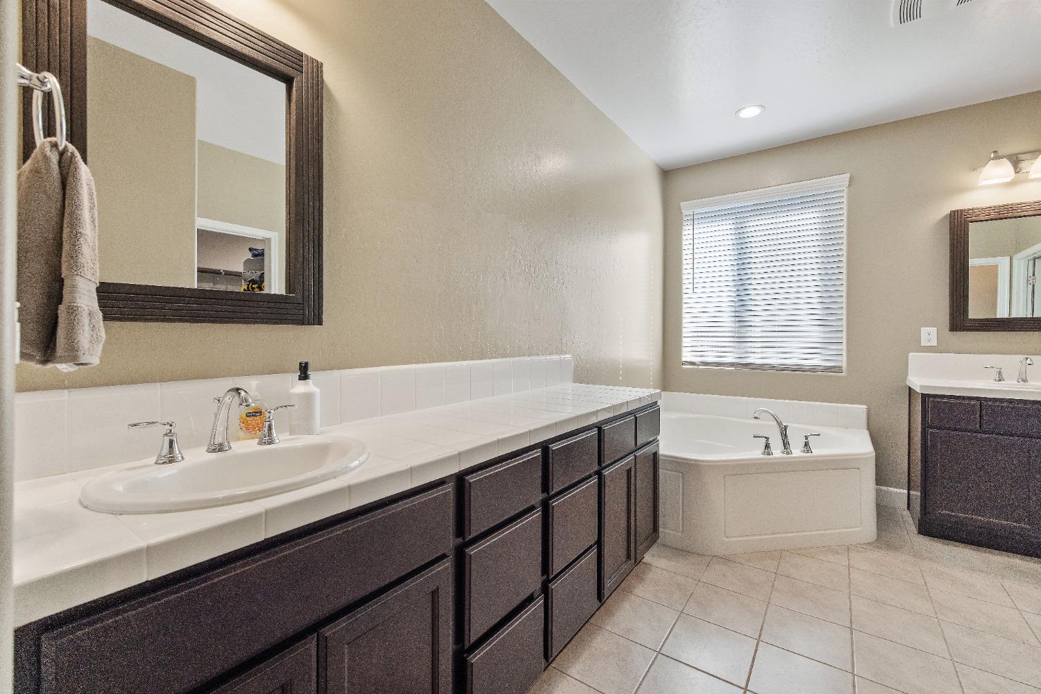 1210 Ridge Creek Estates Way Dinuba, CA 93618 - Photo 33 of 50 a bathroom with a tub sink and mirror