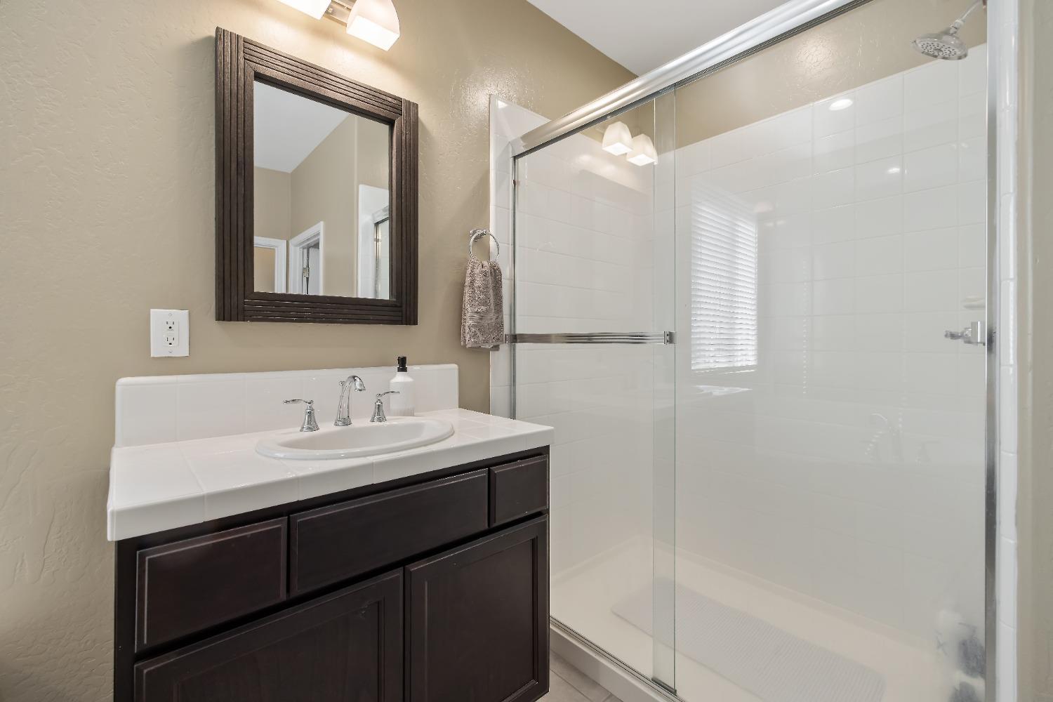 1210 Ridge Creek Estates Way Dinuba, CA 93618 - Photo 36 of 50 a bathroom with a bath tub sink mirror and vanity
