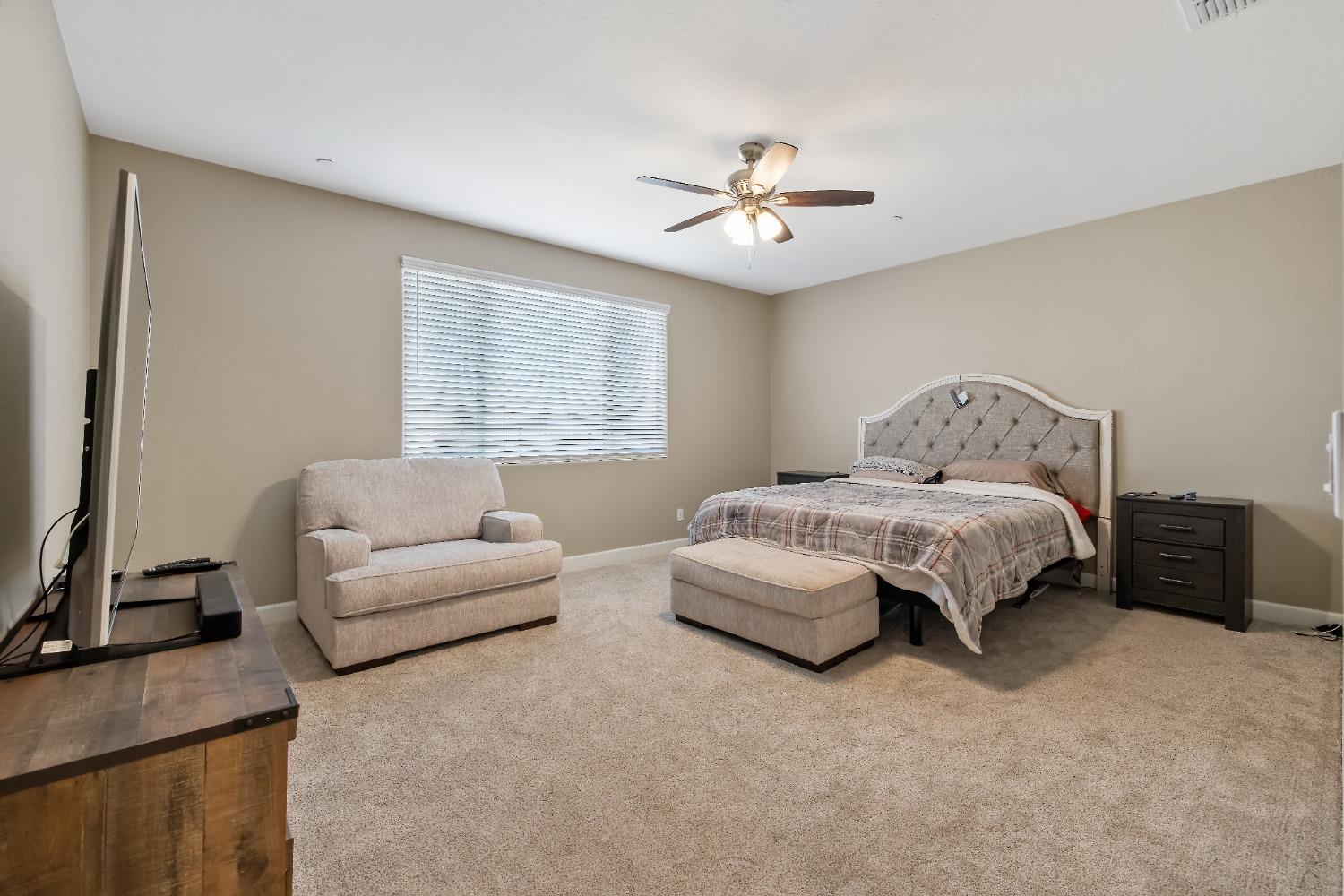 1210 Ridge Creek Estates Way Dinuba, CA 93618 - Photo 39 of 50 a bedroom with a large bed and a couch