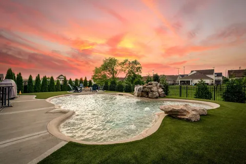 a view of a backyard with table and chairs a fire pit and yard
