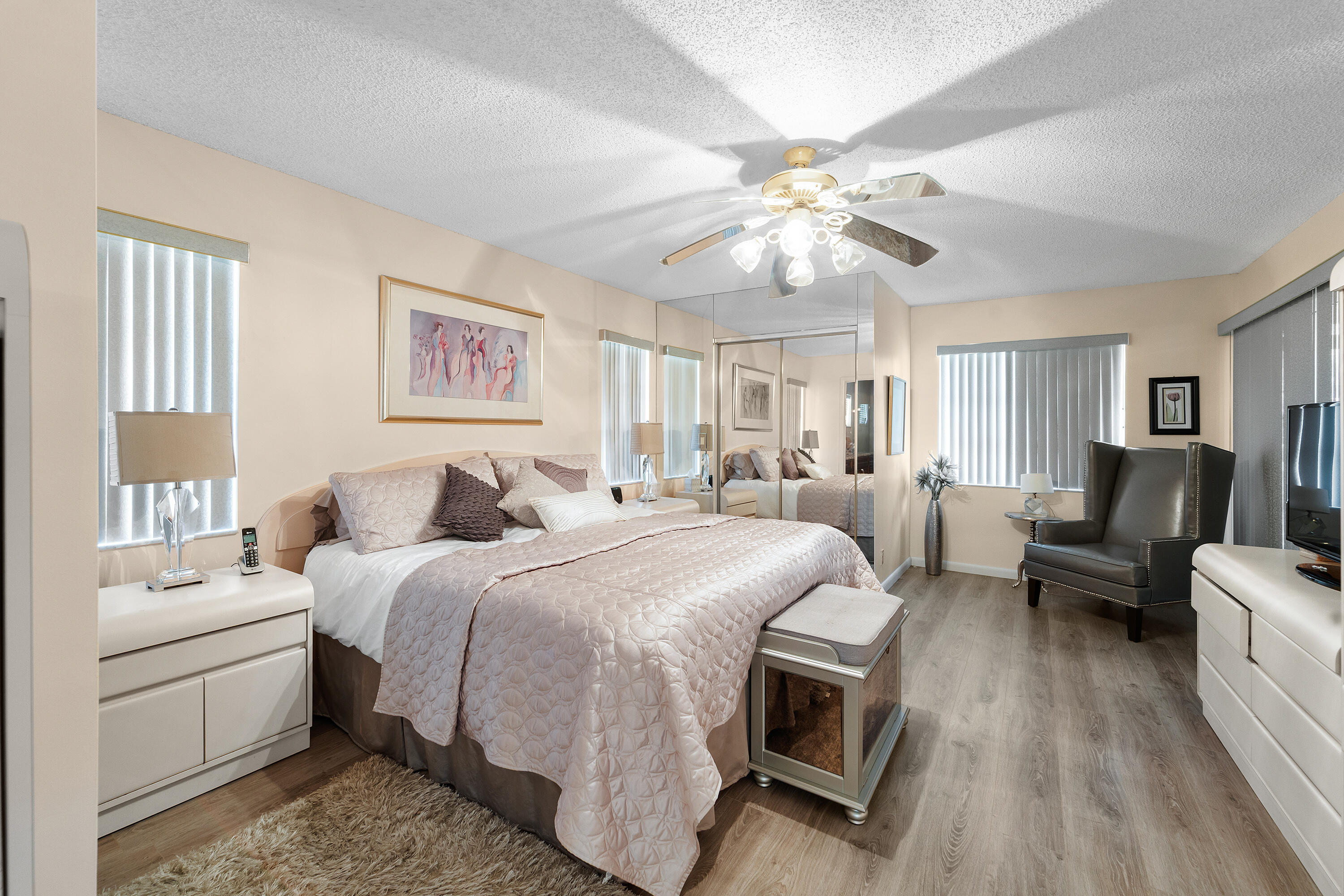 6339 Mill Pointe Circle Delray Beach, FL 33484 - Photo 21 of 61 a spacious bedroom with a bed a couch and a chandelier
