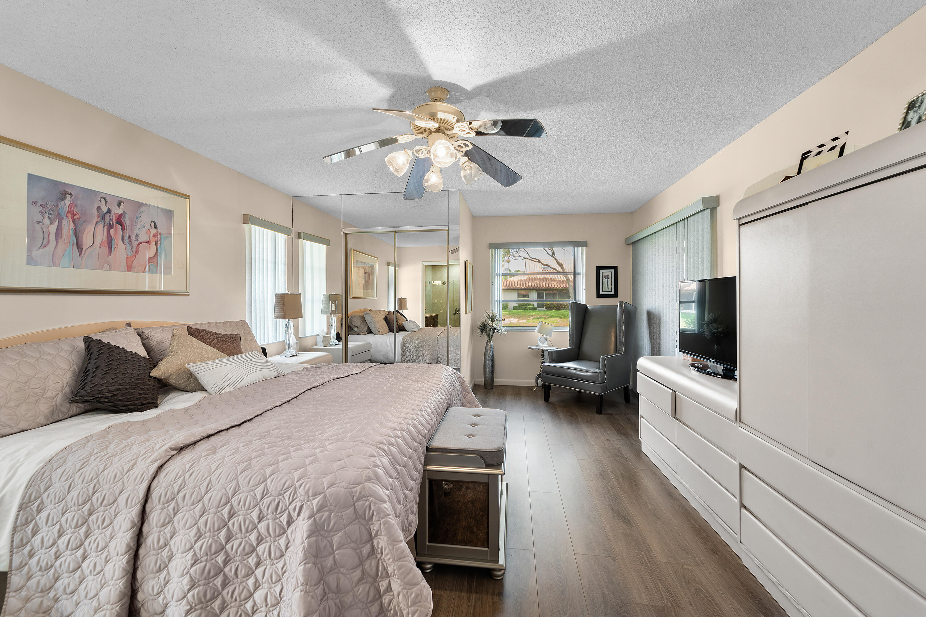 6339 Mill Pointe Circle Delray Beach, FL 33484 - Photo 22 of 61 a bedroom with a large bed and a chandelier