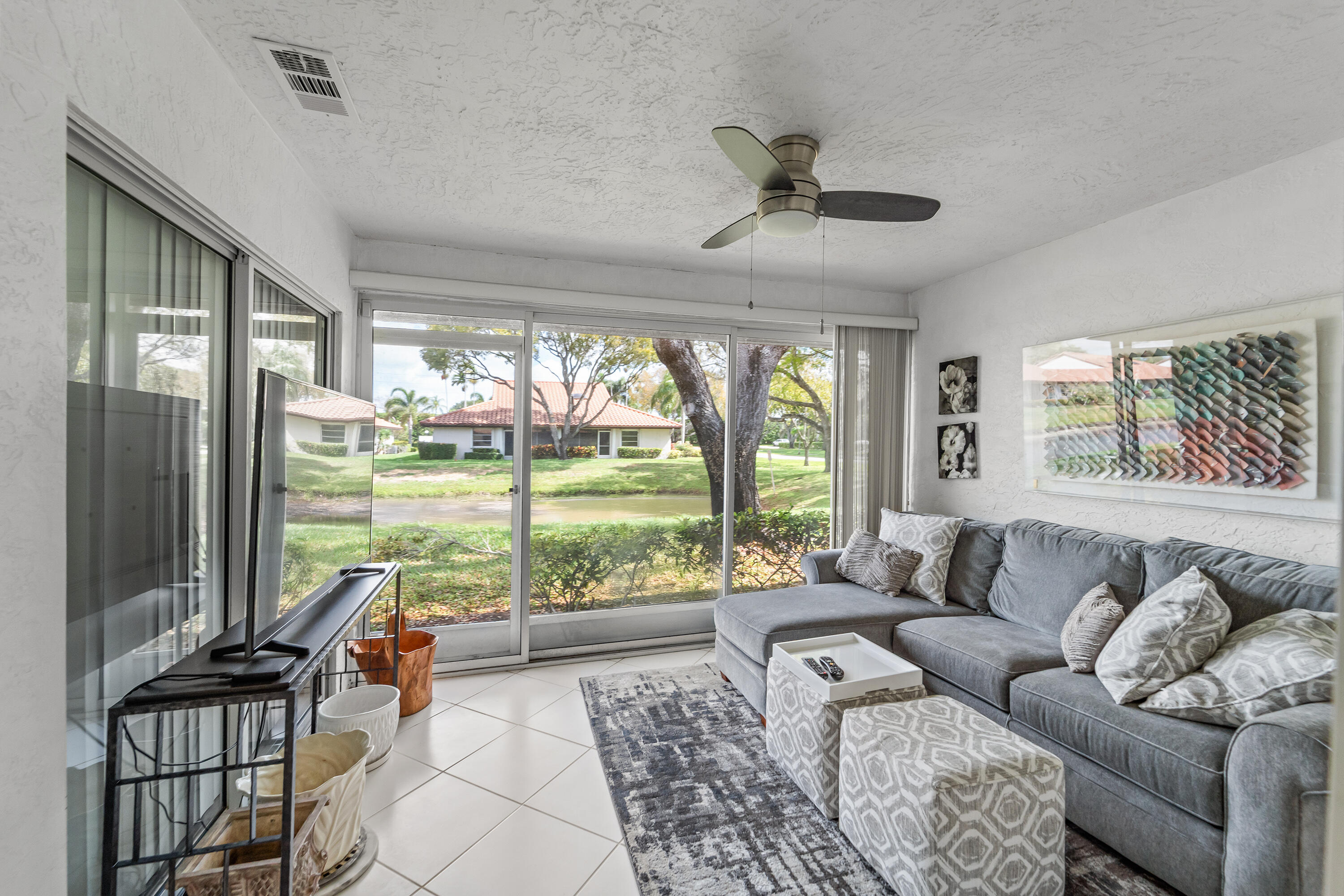 6339 Mill Pointe Circle Delray Beach, FL 33484 - Photo 29 of 61 a living room with furniture and floor to ceiling windows
