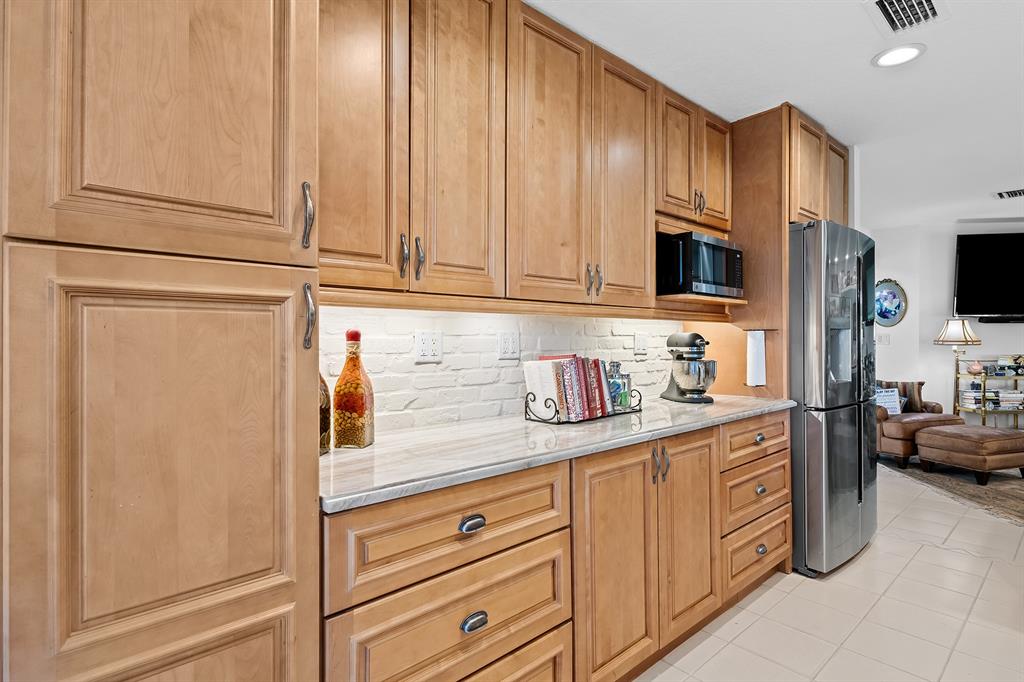 10270 Silver Lake Drive Boca Raton, FL 33428 - Photo 11 of 44 a kitchen with stainless steel appliances granite countertop a refrigerator a stove and a sink with wooden cabinets