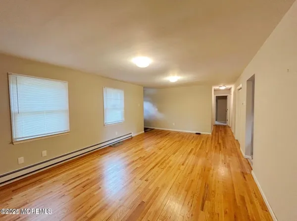 a view of empty room with wooden floor