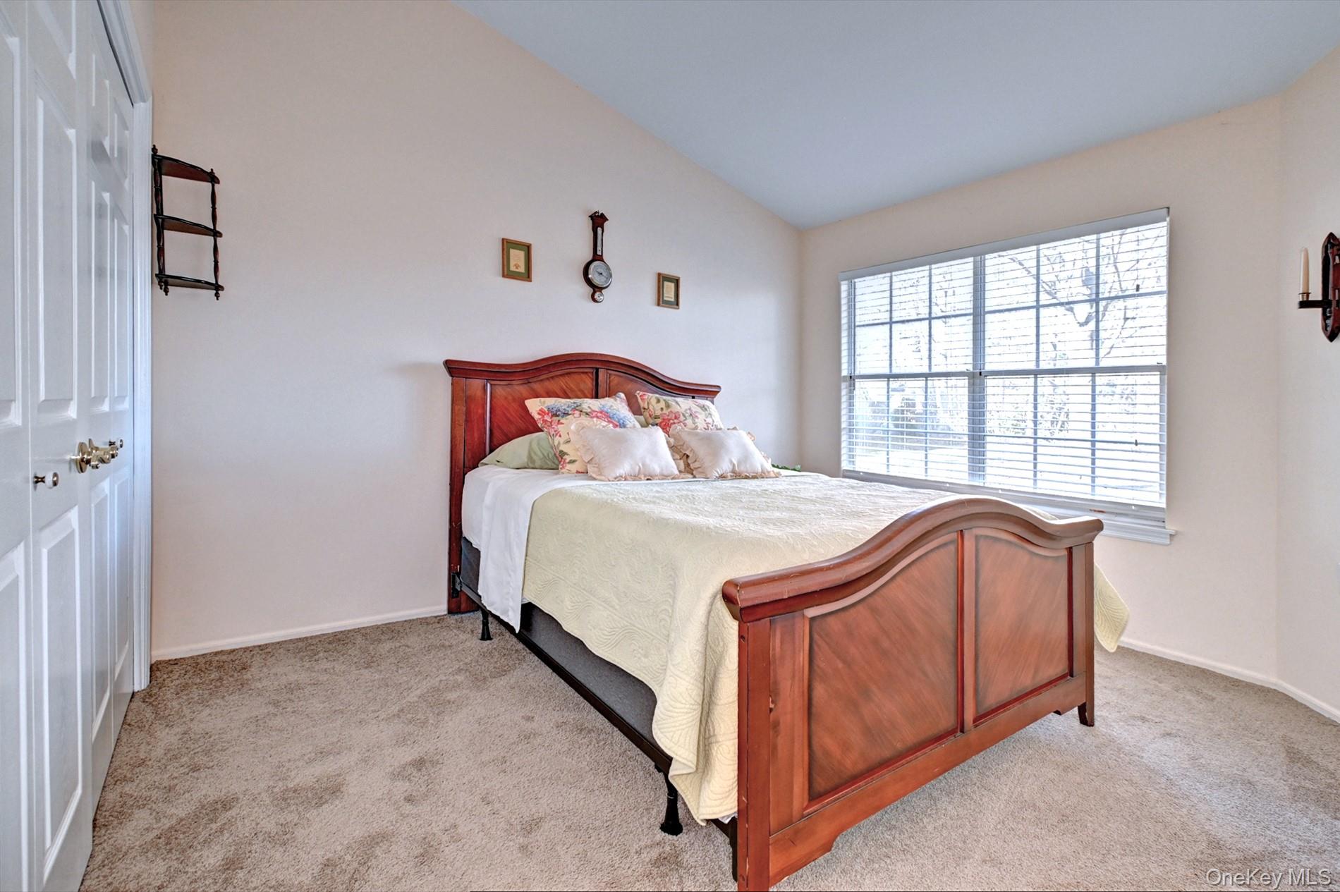 10 Oakdale Court Ridge, NY 11961 - Photo 19 of 41 a bed sitting in a bedroom next to a window