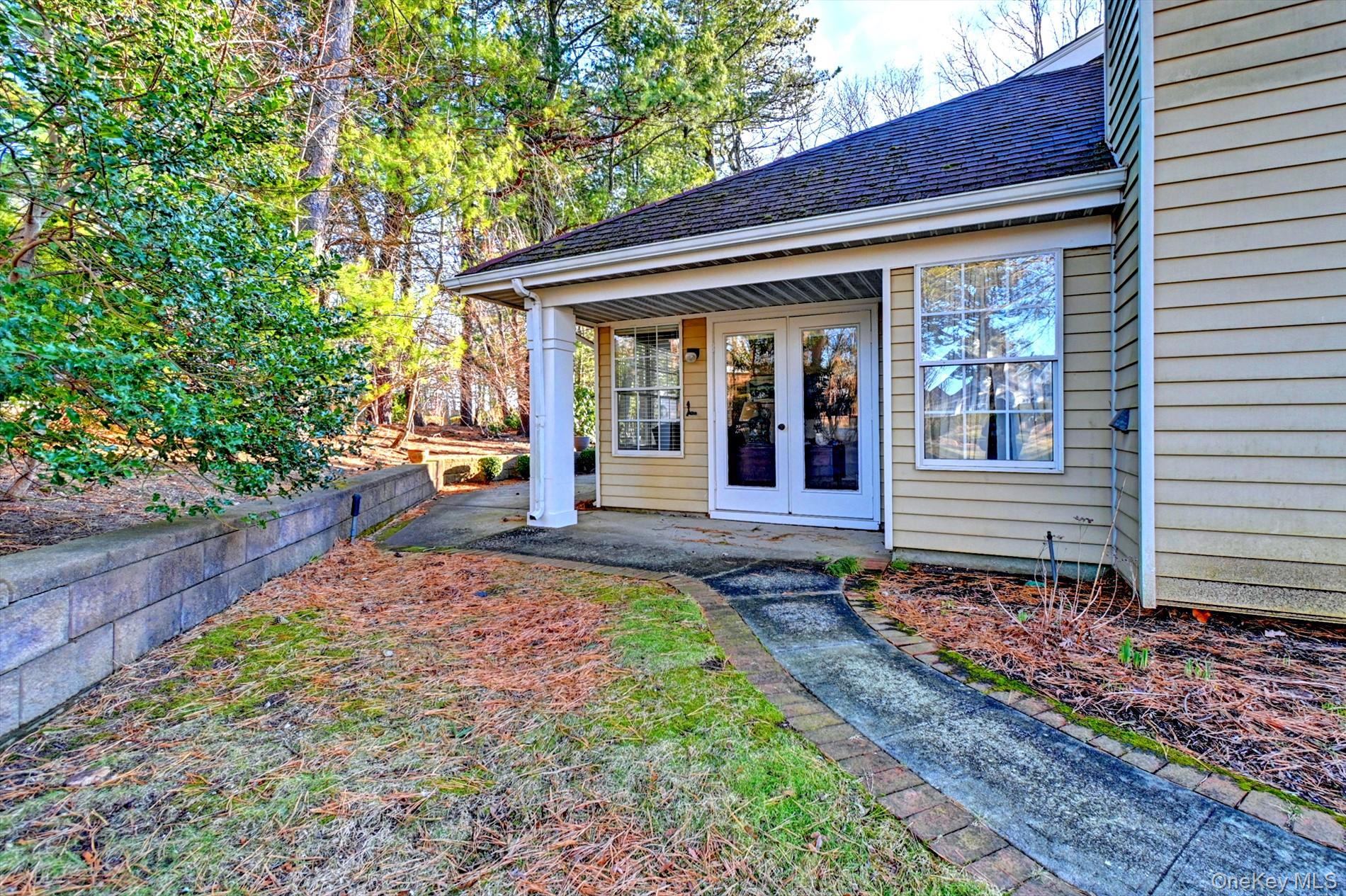 10 Oakdale Court Ridge, NY 11961 - Photo 22 of 41 a view of a house with a small yard plants and large tree