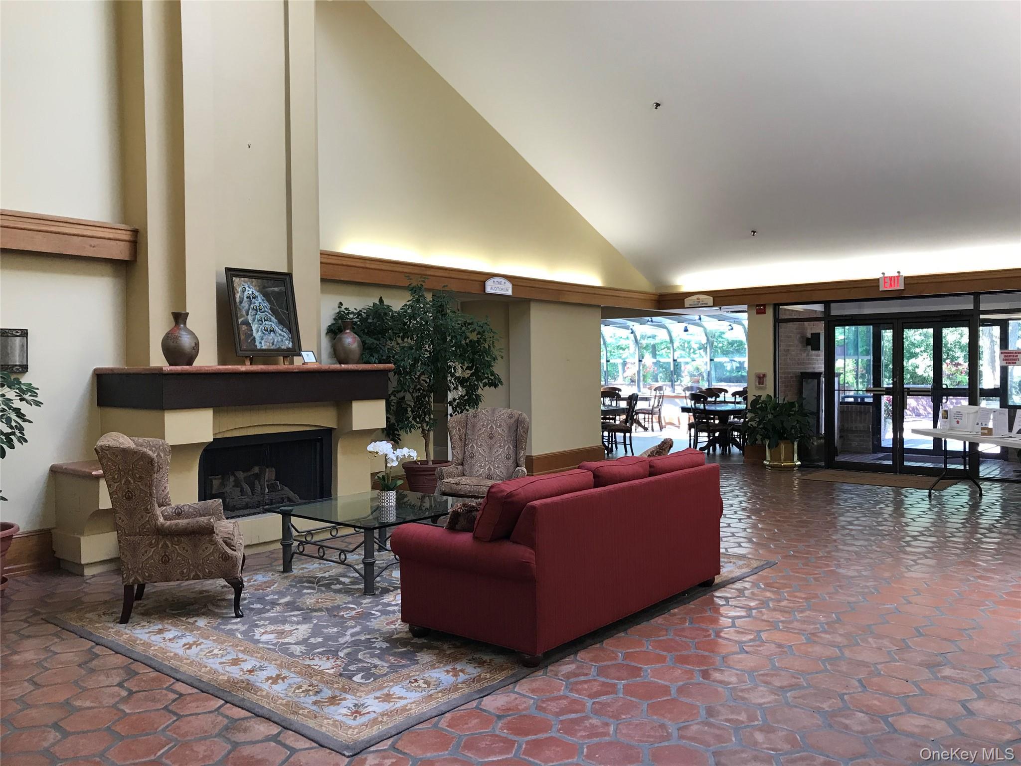 10 Oakdale Court Ridge, NY 11961 - Photo 26 of 41 a living room with furniture a fireplace and a floor to ceiling window