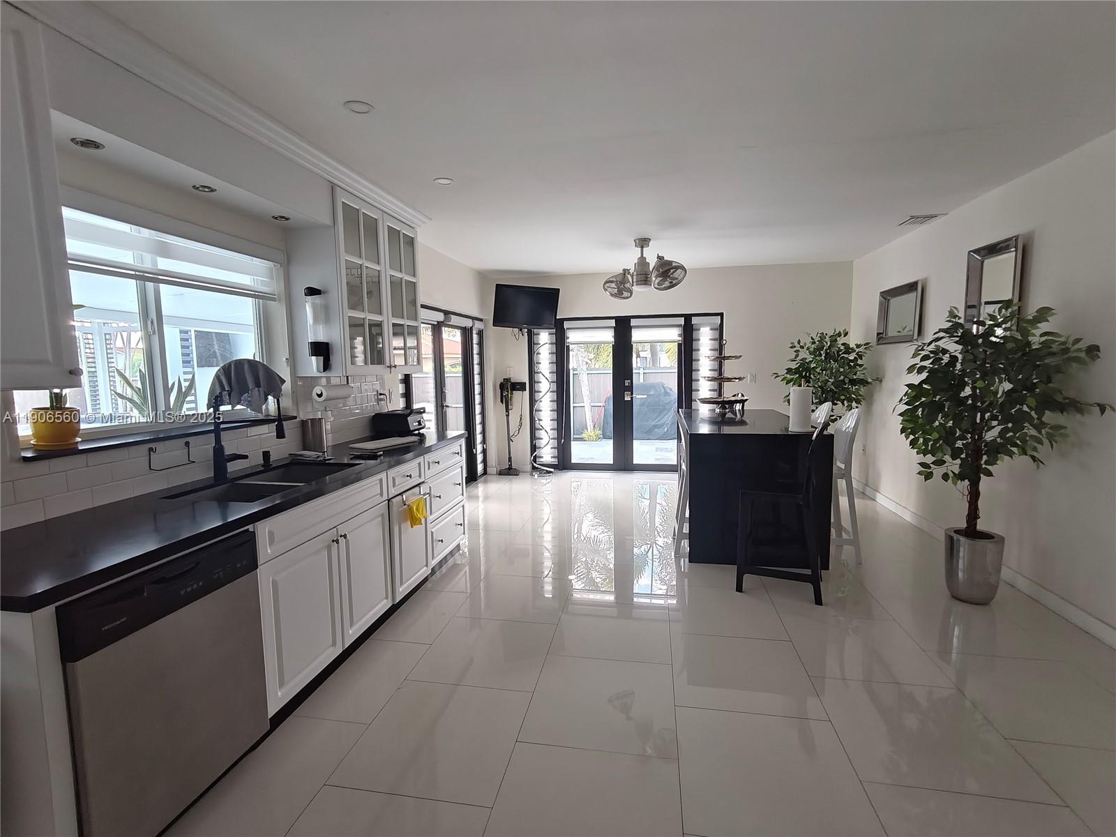 14444 Southwest 107th Terrace Miami, FL 33186 - Photo 11 of 73 a large white kitchen with granite countertop a sink and a dishwasher
