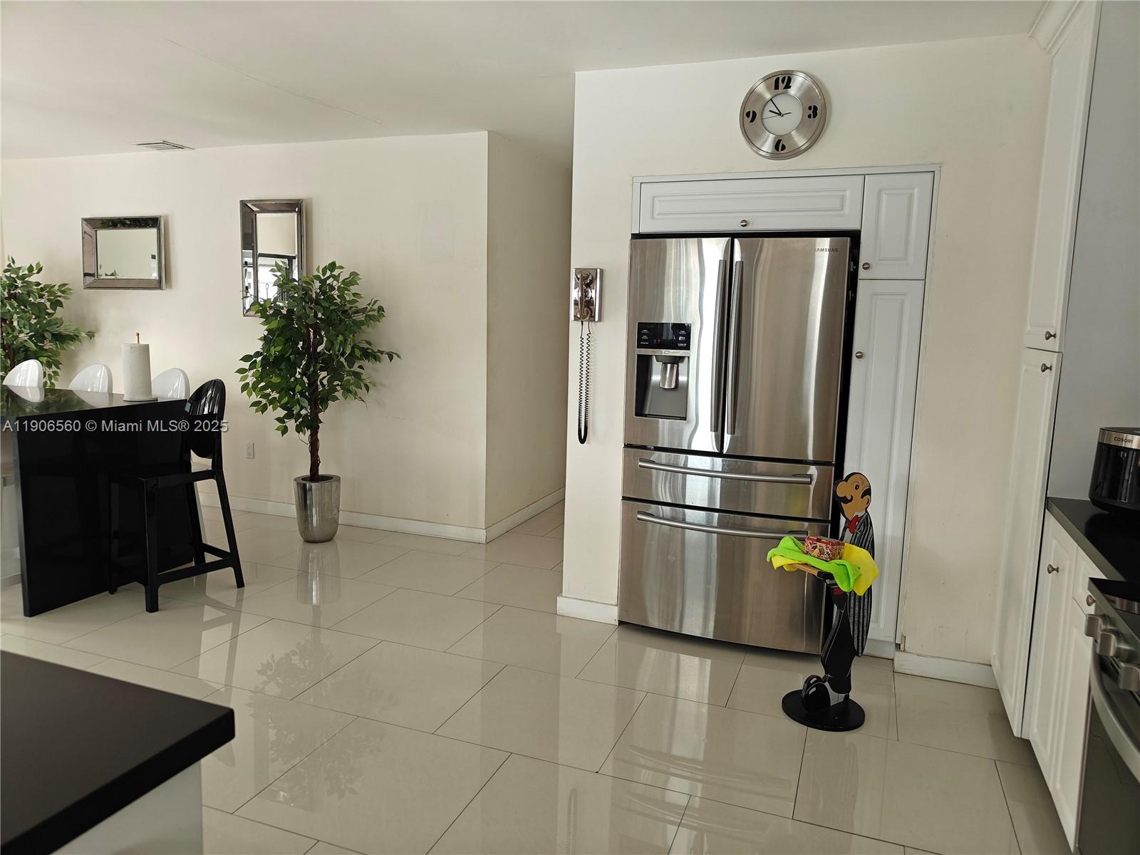 14444 Southwest 107th Terrace Miami, FL 33186 - Photo 12 of 73 a hallway with a potted plant on a table and paintings on the wall